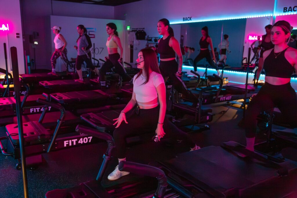 Instructor teaching reformer pilates exercise to the studio members